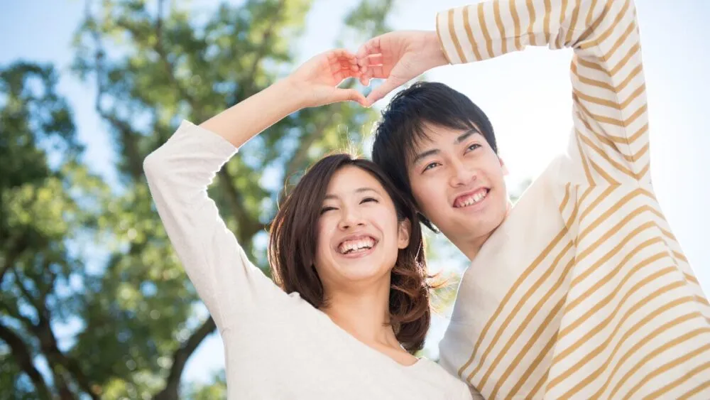一男一女用手比划出一个心形。