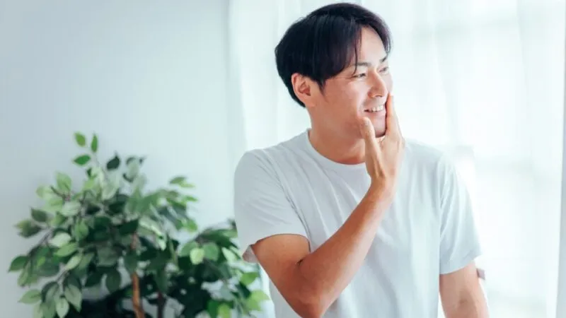 ひげをさわる若い男性