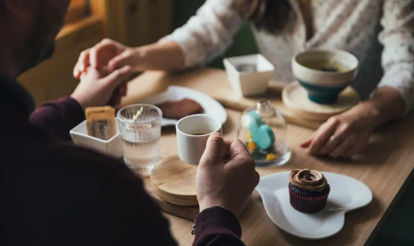 食事をしながら手を繋ぐ男女の様子