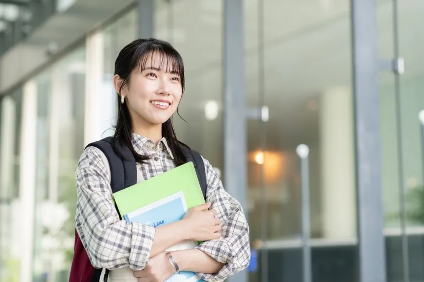 本を持って歩く女性