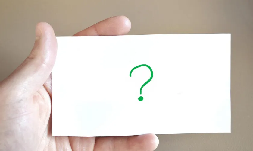 ?のカードを持った手の画像