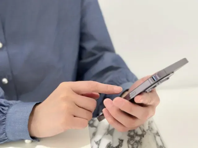 携帯を触る女性の手元