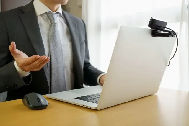 パソコンの前で話す男性