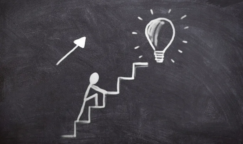 階段を上る人物と電球の絵