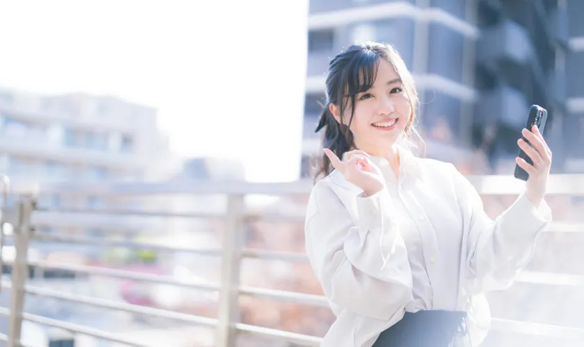 スマートフォンを持った笑顔の女性