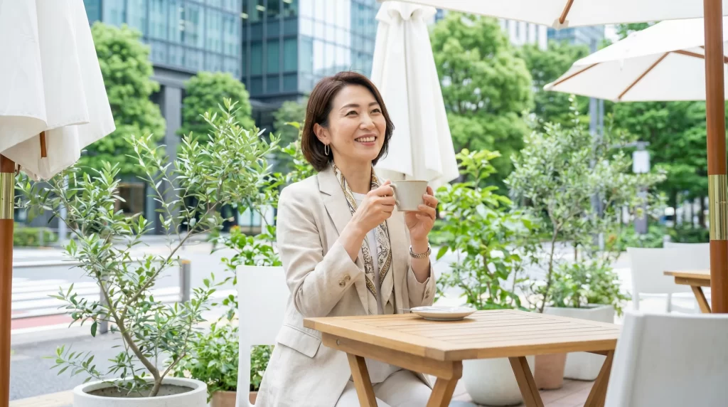 自信に満ちた40代の女性がカフェテラスでコーヒーを楽しんでいる